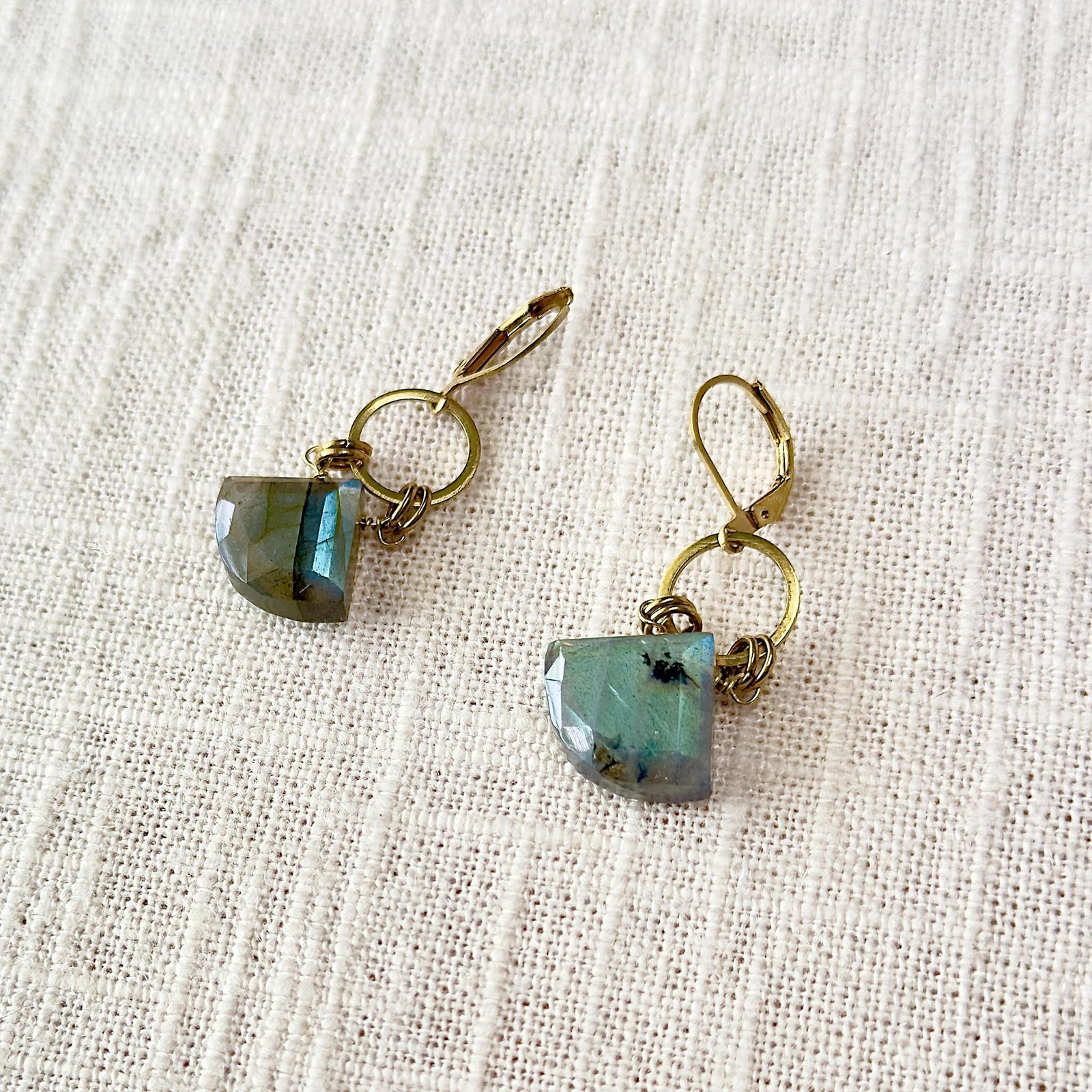 The Spellcrafter Labradorite Diamond Earrings feature hypoallergenic brass lever-backs and geometric blue-green gemstone pendants,...