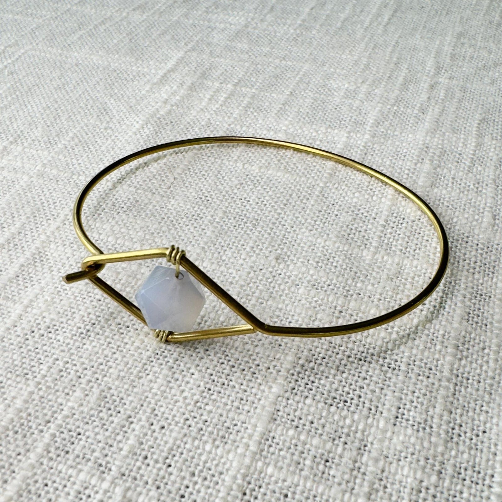 The Spellcrafter Blue Lace Agate Wire Bracelet features a faceted gemstone symbolizing the Throat...