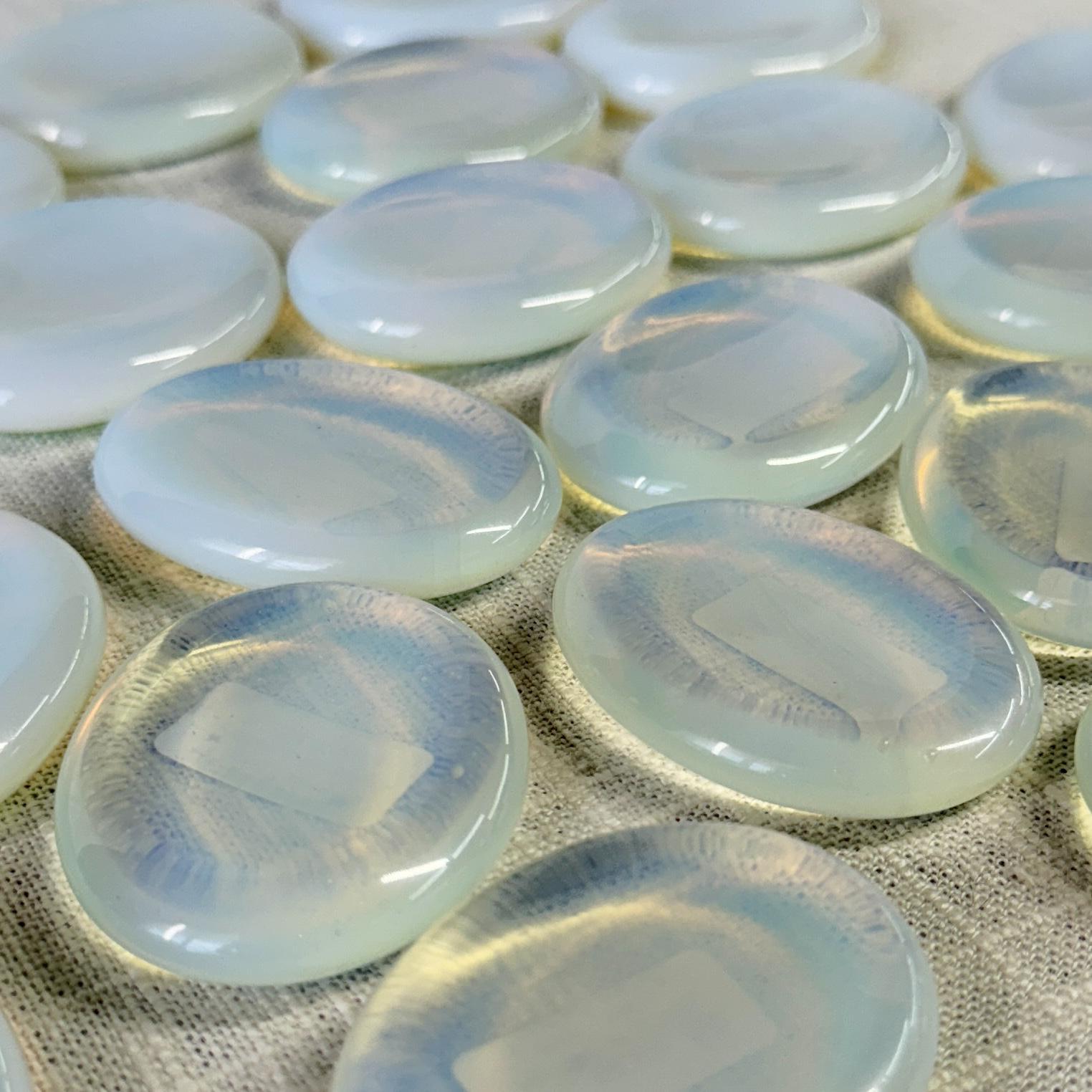 Spellcrafter's Opalite Calming Stones feature smooth, oval shapes and a milky, iridescent glow with soft blue and yellow hues—ideal for meditation and fostering calming energy.