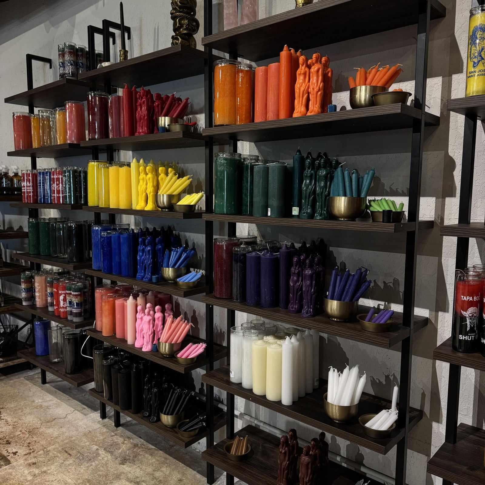 Shelves filled with Spellcrafter’s colorful spell, pillar, taper, and human figure candles inspire your...