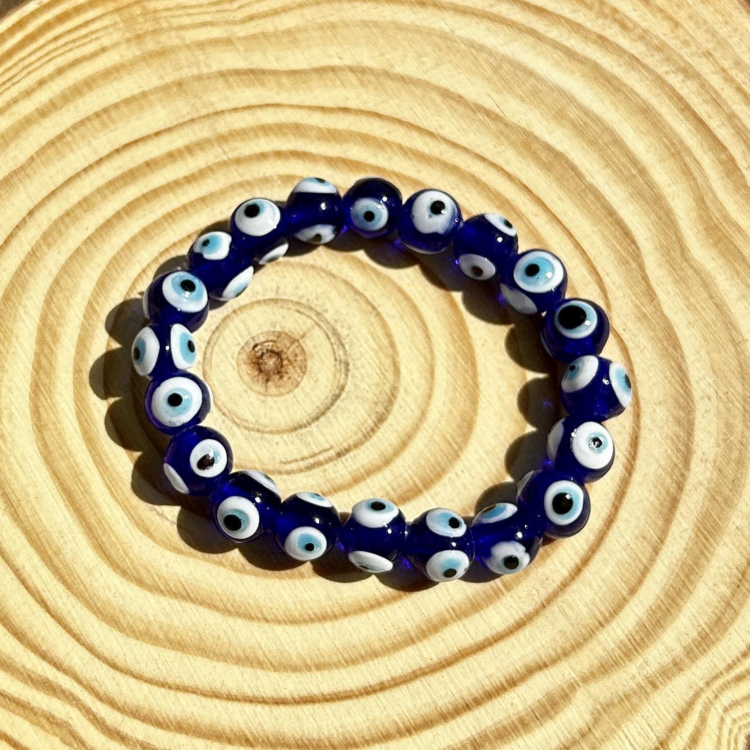 The Spellcrafter Evil Eye Beaded Bracelet, featuring dark blue beads with signature eye-like designs,...