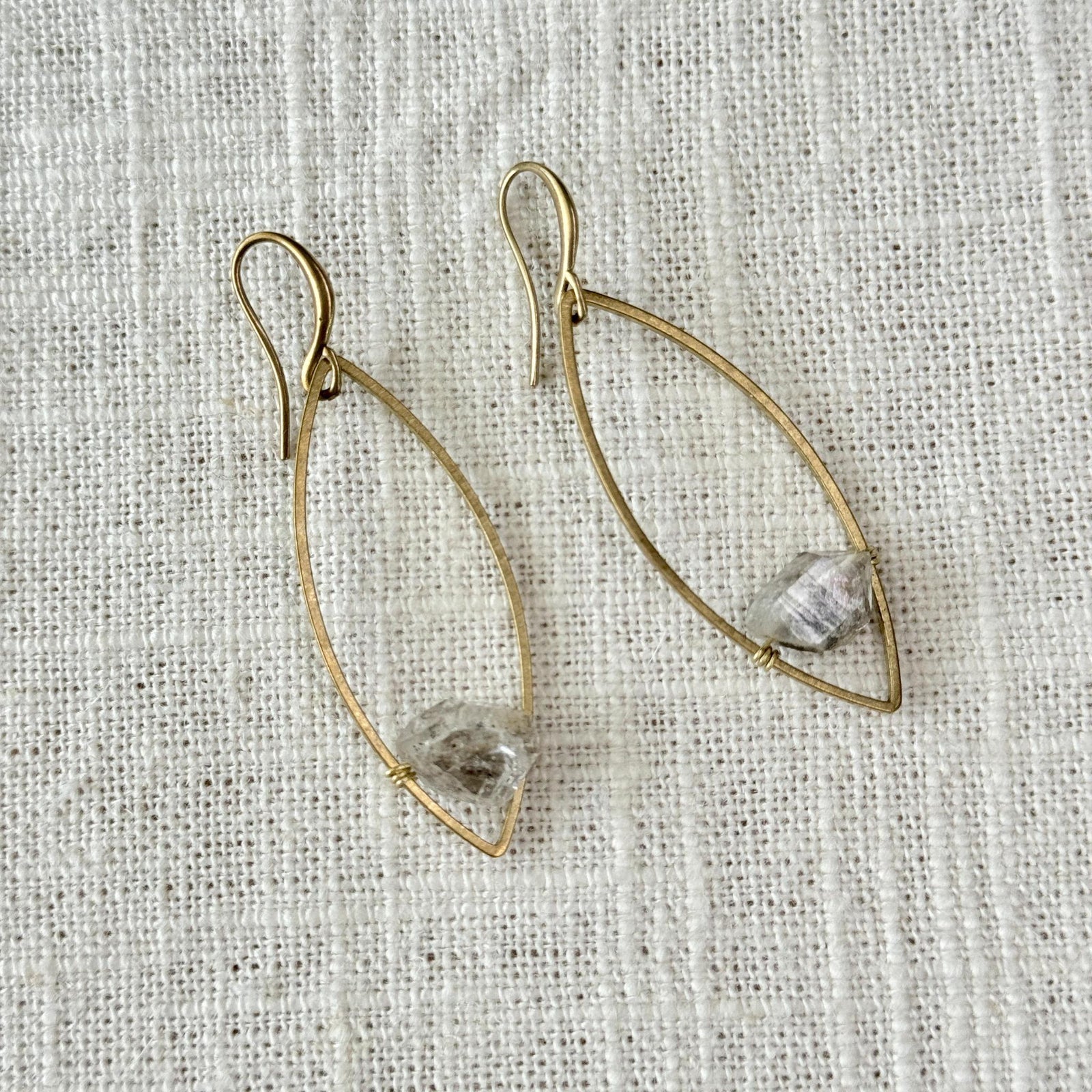 Spellcrafter's Herkimer Floating Marquise Earrings feature gold wire marquise shapes with a small, rough...
