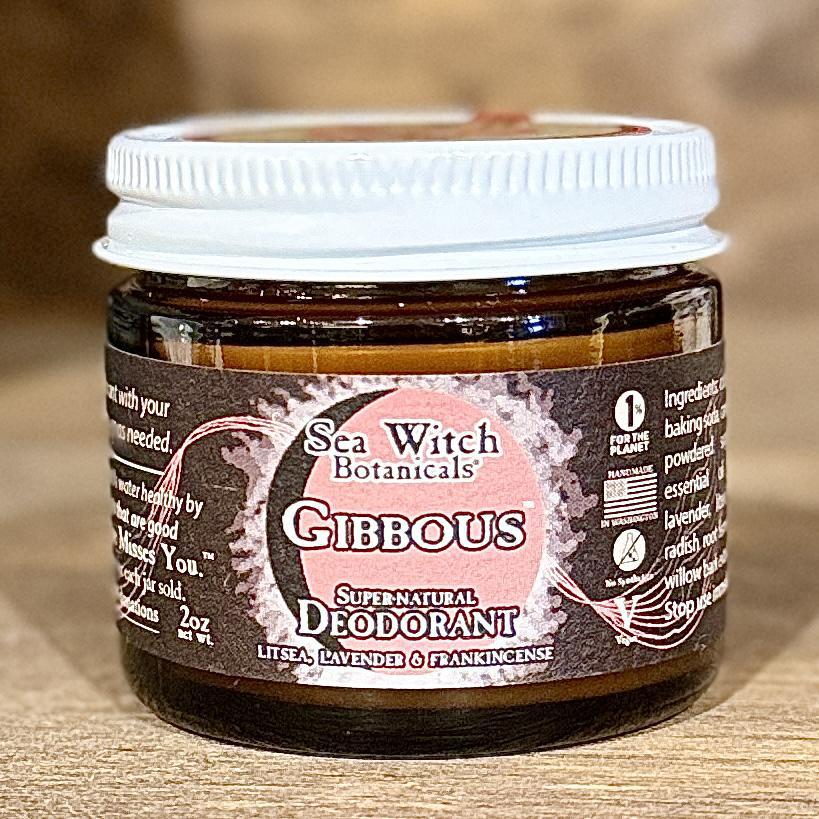 A small glass jar of Spellcrafter SuperNatural Deodorant with a white lid, featuring a pink and brown label listing litsea, lavender, and frankincense. This gentle, aluminum-free deodorant is both natural and effective.