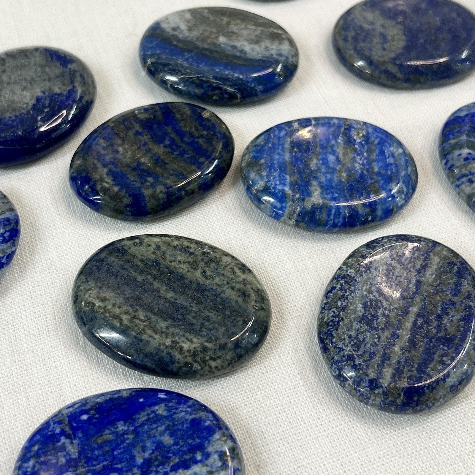 Spellcrafter’s Lapis Lazuli Calming Stones, polished ovals with dark blue and gray streaks, display...